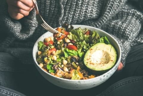 Woman eating fresh salad, avocado, beans and vegetables, square crop Woman eating fresh salad, avocado, beans and vegetables, square crop