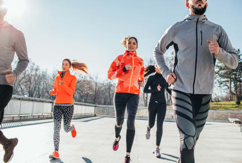 Group of Friends Running Outdoors in Cold Weather Group of Friends Running Outdoors in Cold Weather