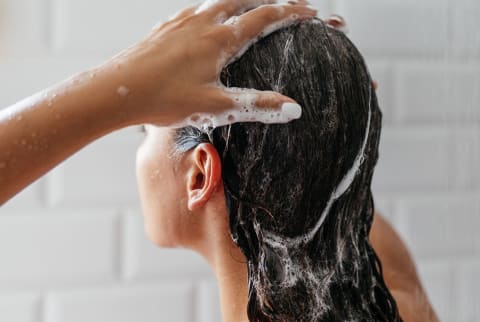woman washing hair in shower woman washing hair in shower