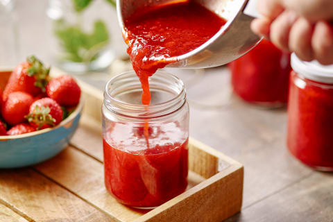 Hand Pouring Jam From Pan In Can Hand Pouring Jam From Pan In Can