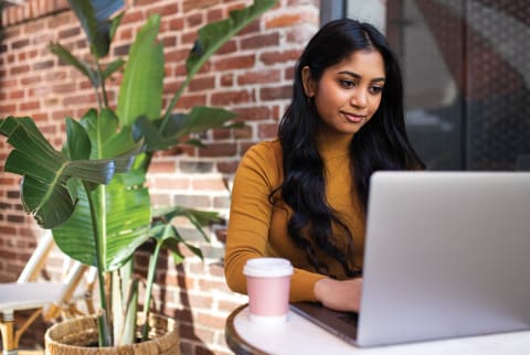 woman sitting outside looking at laptop woman sitting outside looking at laptop